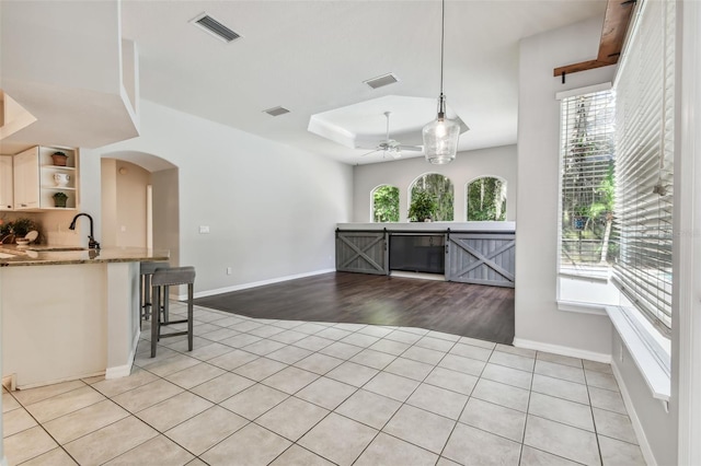 kitchen with pendant lighting, a breakfast bar, light hardwood / wood-style floors, and a wealth of natural light