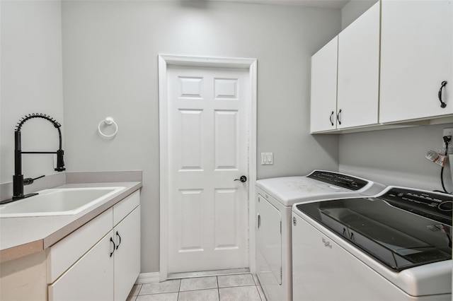 laundry area with washer and clothes dryer, sink, light tile patterned floors, and cabinets