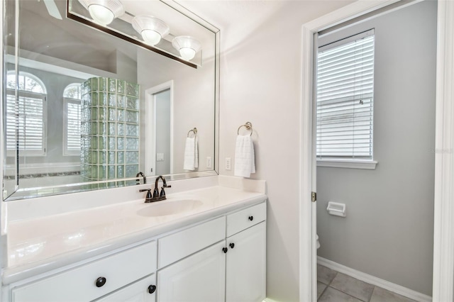 bathroom featuring a wealth of natural light, tile patterned floors, vanity, and toilet