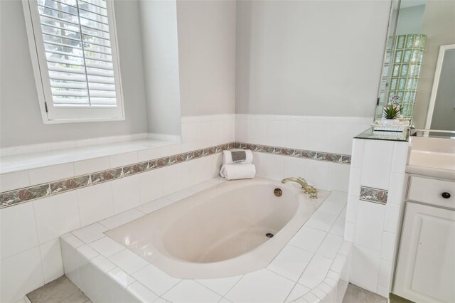 bathroom with tiled bath and vanity