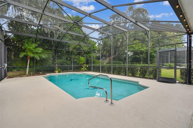 view of pool with glass enclosure and a patio