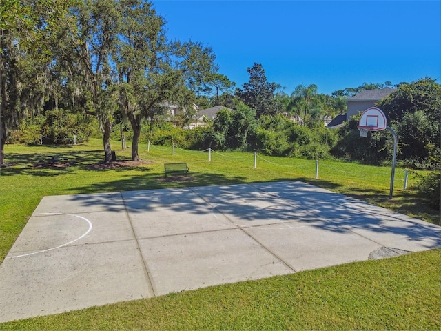 view of sport court with a lawn