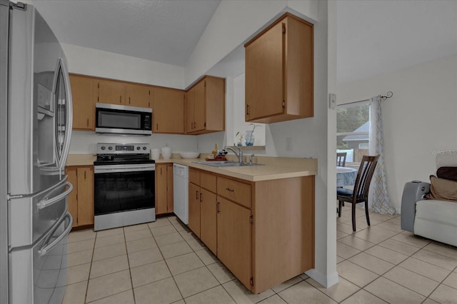 kitchen featuring lofted ceiling, stainless steel appliances, sink, light tile patterned flooring, and light brown cabinetry