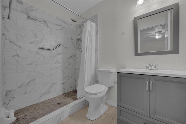 bathroom with tile patterned floors, toilet, walk in shower, vanity, and ceiling fan