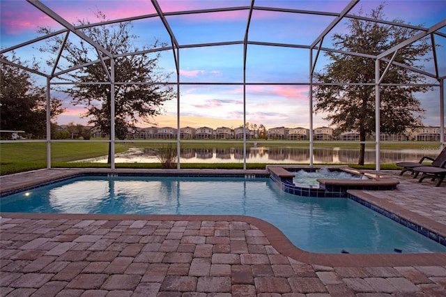 pool at dusk featuring an in ground hot tub, a patio, a water view, and a lanai