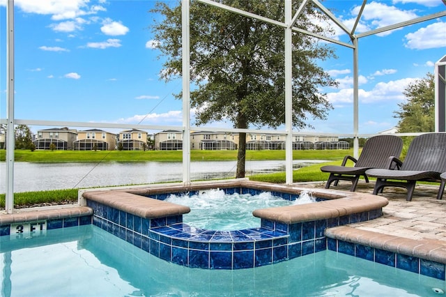 view of pool with pool water feature, glass enclosure, a water view, and a hot tub