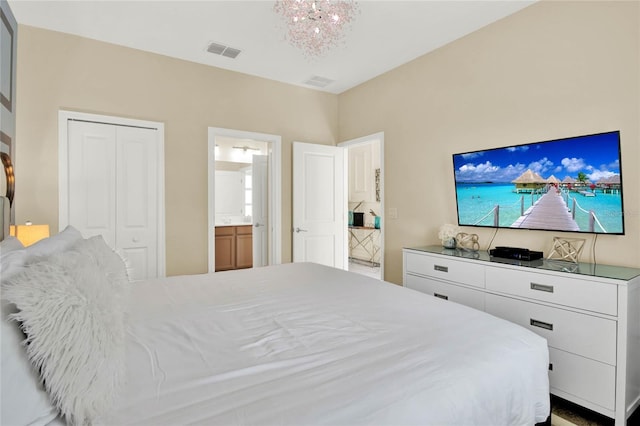 bedroom with ensuite bath and a chandelier