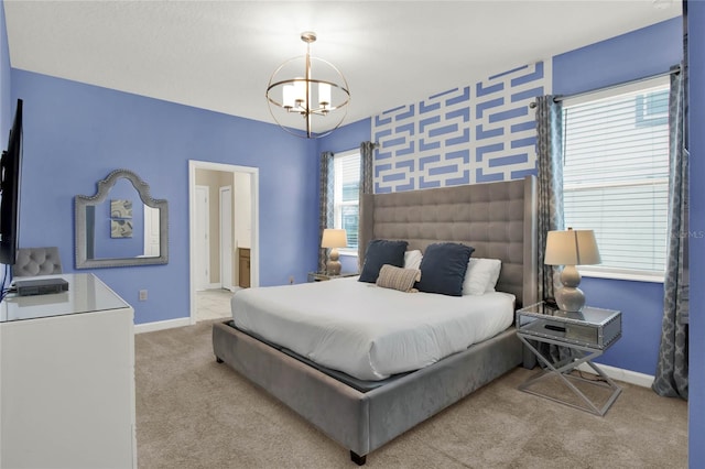 carpeted bedroom with a chandelier and ensuite bath