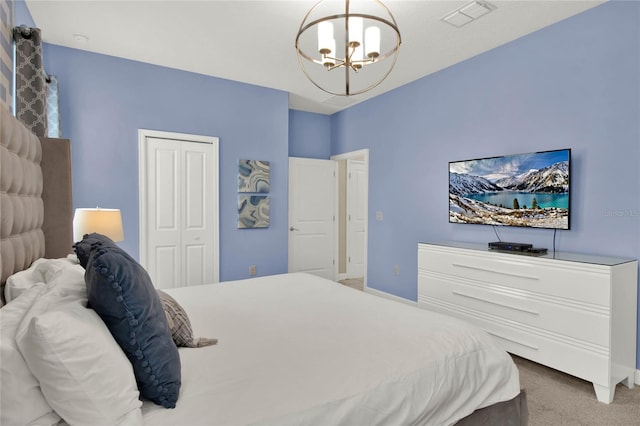 carpeted bedroom with a closet and an inviting chandelier