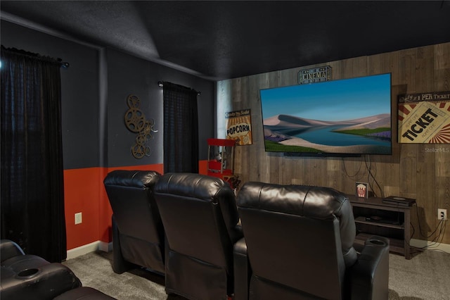 carpeted home theater featuring wooden walls