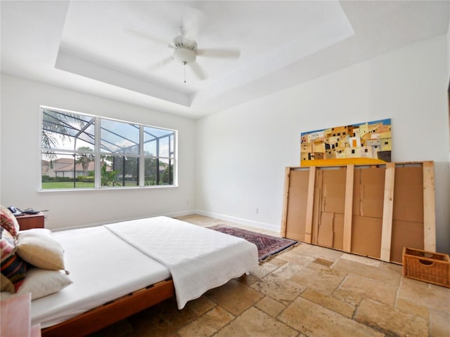 bedroom featuring ceiling fan and a raised ceiling