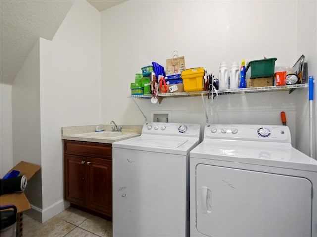 laundry area with light tile patterned floors, washer and clothes dryer, and sink