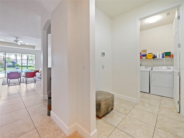 washroom with ceiling fan, light tile patterned floors, a textured ceiling, and washer and dryer