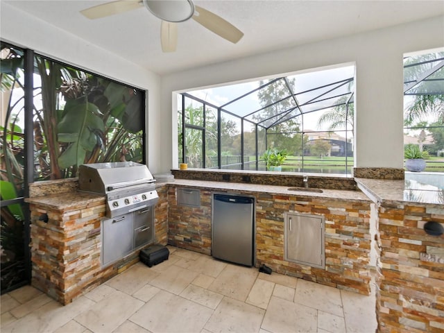 view of patio with a lanai, sink, area for grilling, ceiling fan, and grilling area