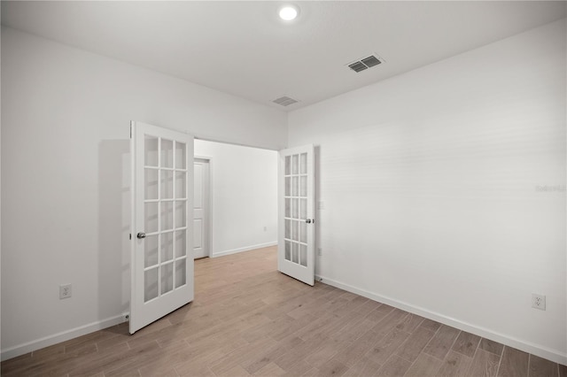 unfurnished room with light hardwood / wood-style flooring and french doors