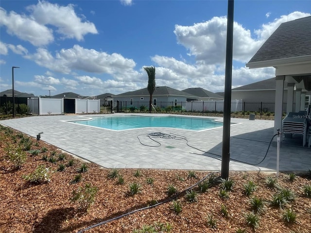 view of swimming pool featuring a patio, fence, and a fenced in pool