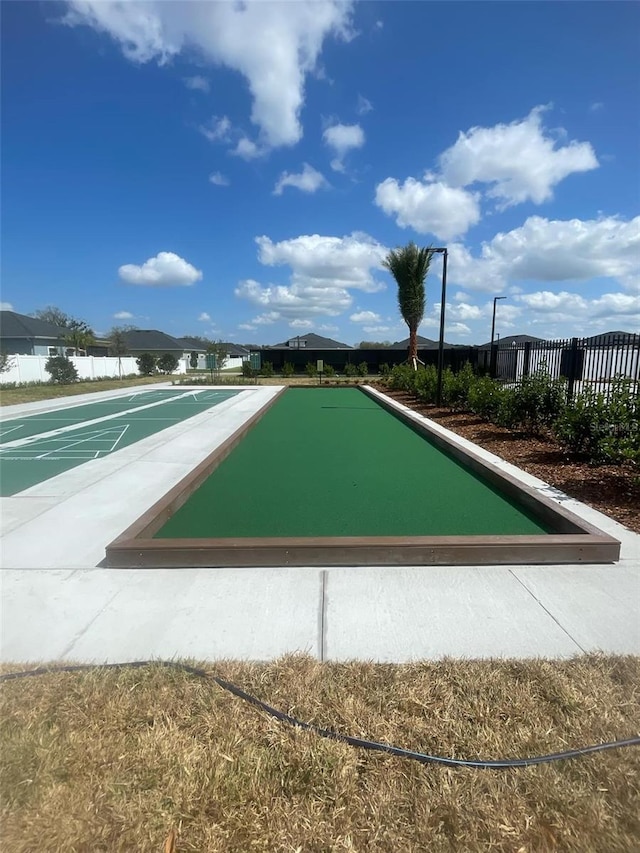 view of home's community featuring shuffleboard and fence