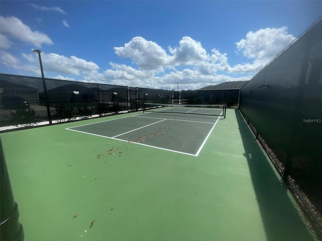 view of tennis court featuring fence