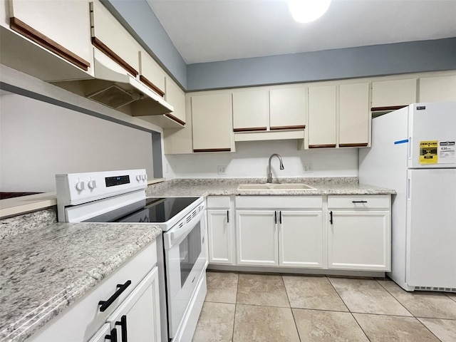 kitchen with white cabinets, light tile patterned floors, light stone countertops, sink, and white appliances