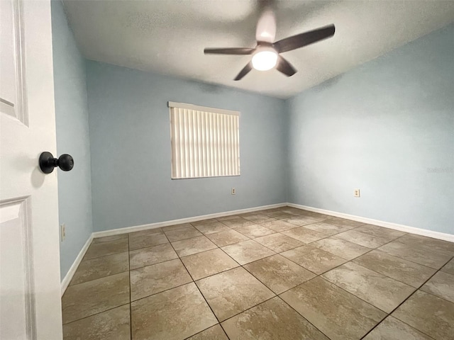 tiled empty room featuring ceiling fan and a textured ceiling