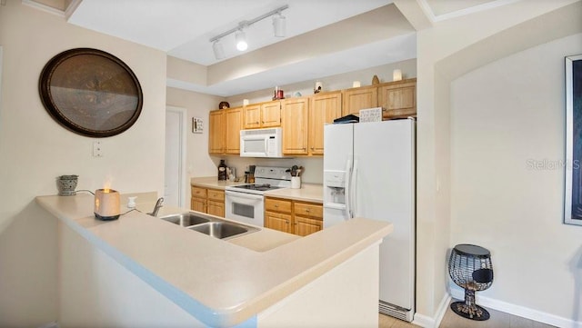 kitchen with track lighting, sink, kitchen peninsula, white appliances, and light brown cabinets