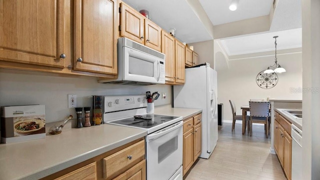 kitchen with a notable chandelier, white appliances, and hanging light fixtures