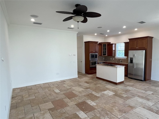 kitchen featuring tasteful backsplash, sink, a kitchen island, appliances with stainless steel finishes, and ornamental molding