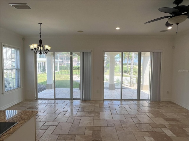 interior space with ceiling fan with notable chandelier and a wealth of natural light