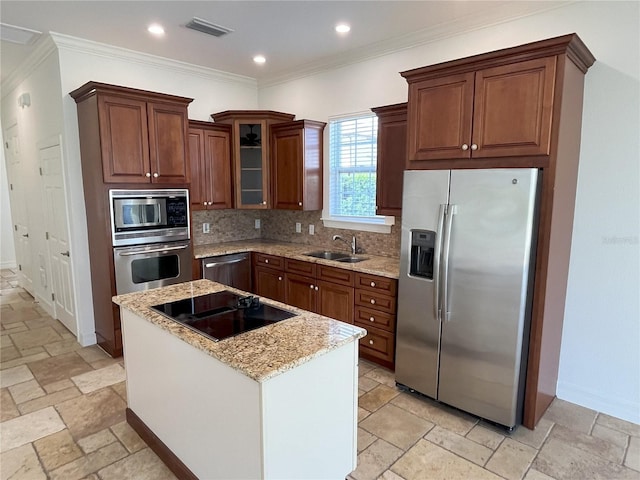 kitchen with appliances with stainless steel finishes, backsplash, a kitchen island, and crown molding