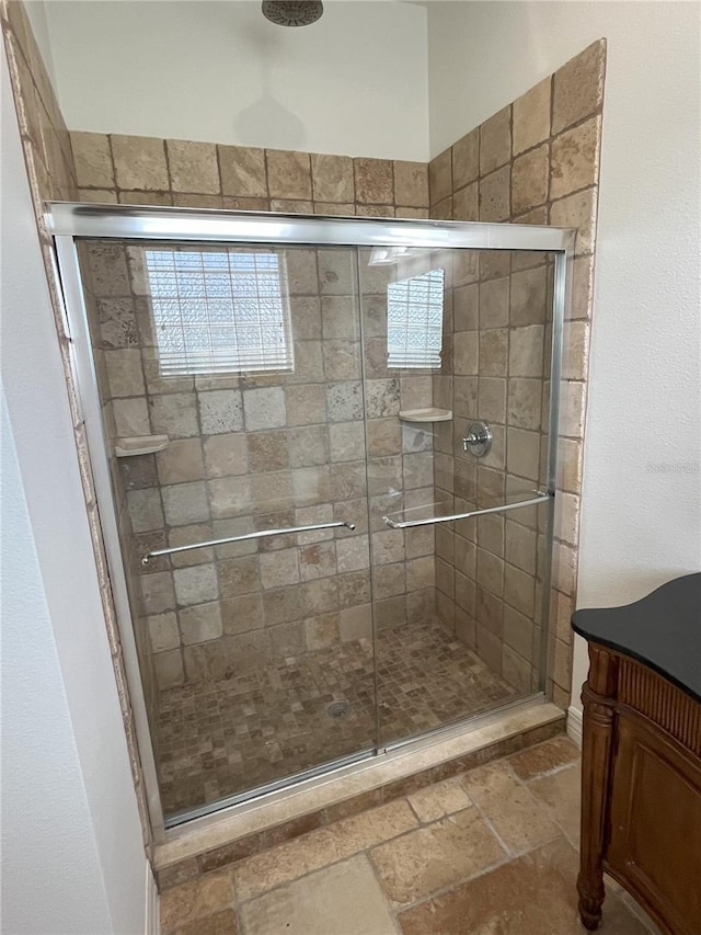 bathroom featuring vanity and a shower with door