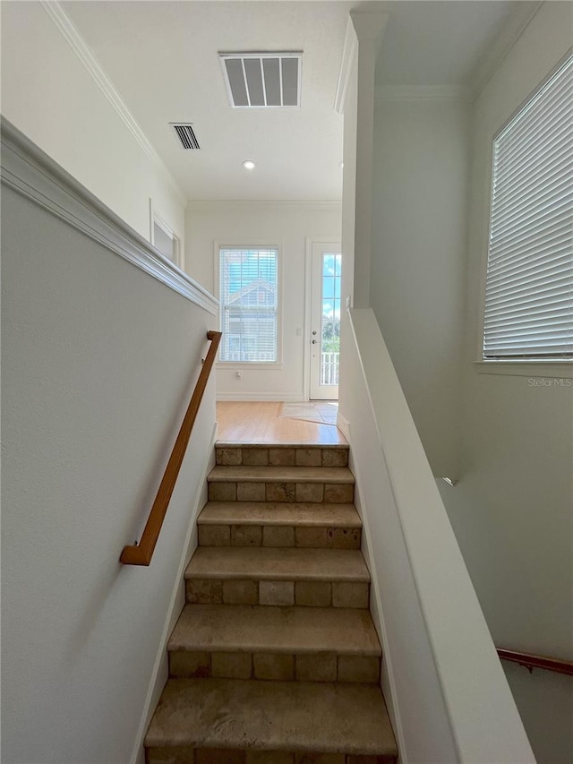 staircase with wood-type flooring and ornamental molding