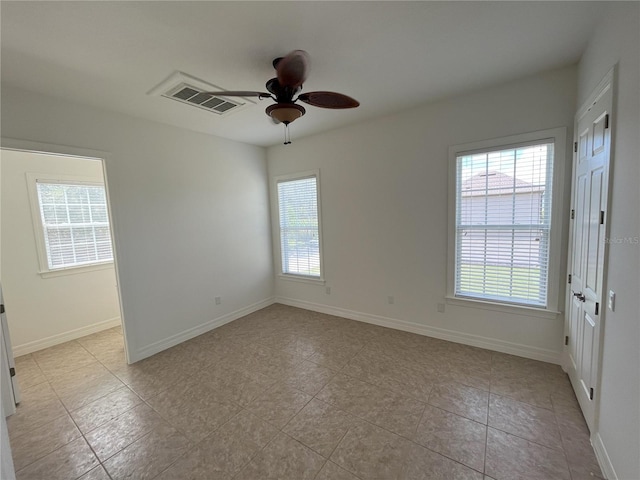 unfurnished room with ceiling fan and a wealth of natural light