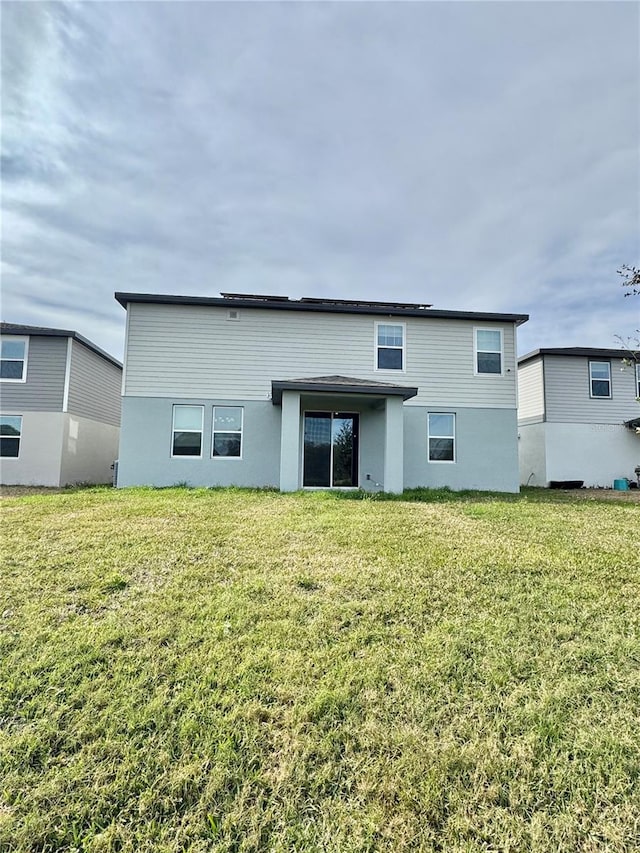 rear view of property with a lawn