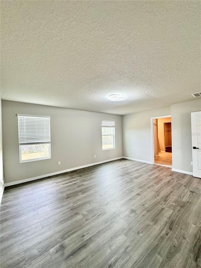 empty room featuring hardwood / wood-style flooring and a textured ceiling