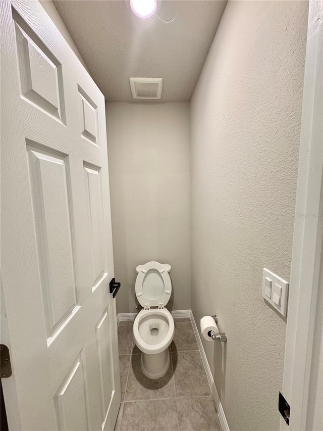 bathroom with toilet and tile patterned flooring