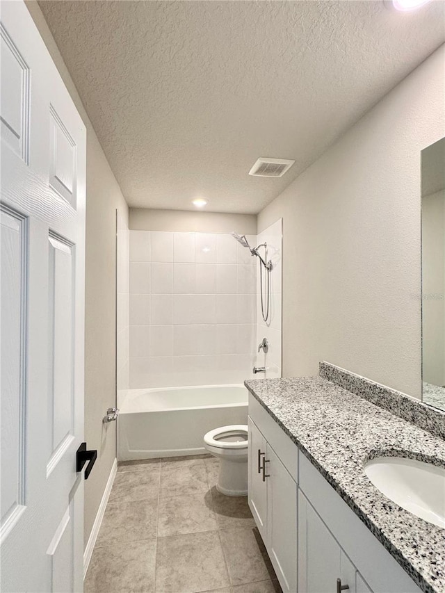 full bathroom featuring vanity, toilet, tiled shower / bath combo, and a textured ceiling