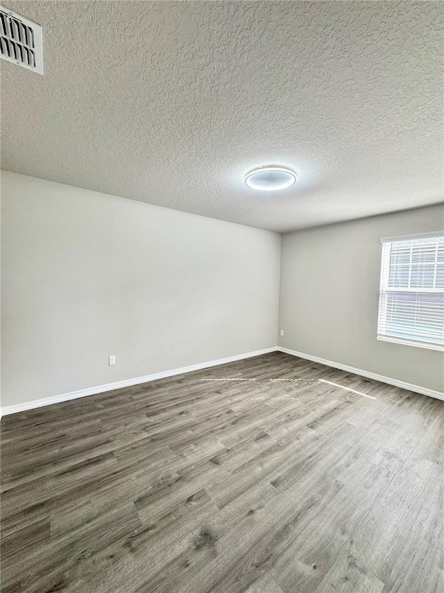 empty room featuring hardwood / wood-style floors and a textured ceiling