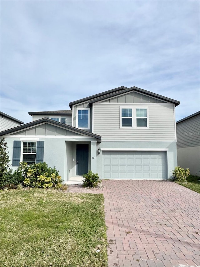 view of property featuring a garage and a front yard