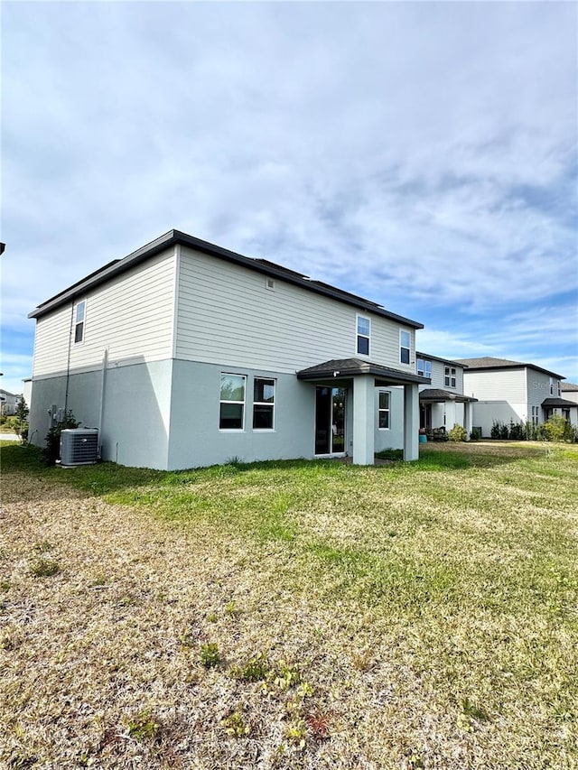 back of house with cooling unit and a yard