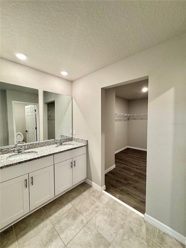 bathroom with vanity, tile patterned floors, and a textured ceiling