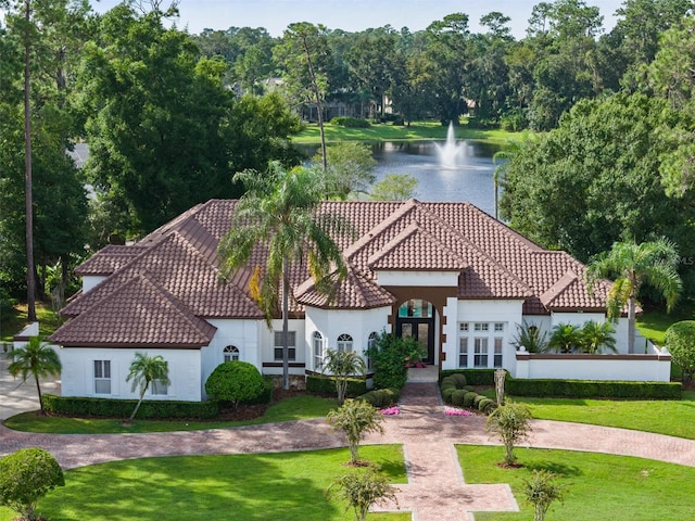 view of front facade with a front yard, french doors, and a water view