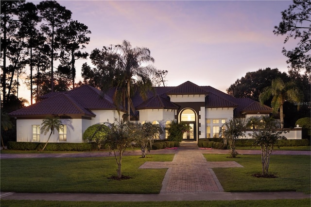 mediterranean / spanish house featuring a lawn