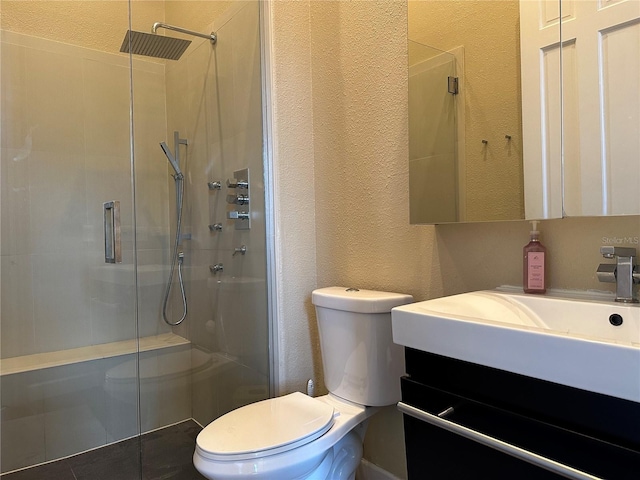 bathroom featuring a shower with door, vanity, and toilet