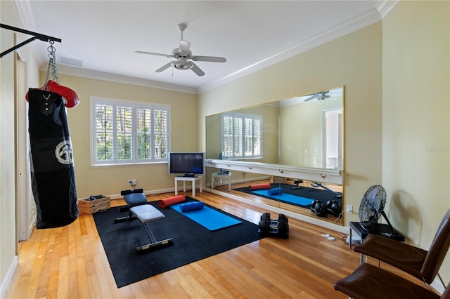 exercise room featuring wood-type flooring, ornamental molding, and ceiling fan