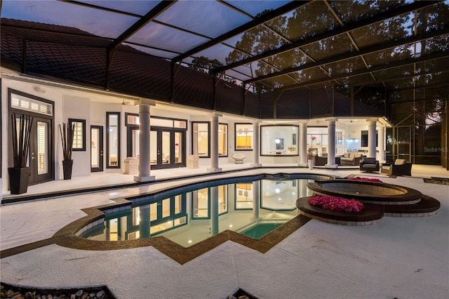 view of swimming pool with glass enclosure, an in ground hot tub, and a patio area