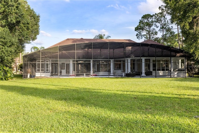 rear view of house with a lawn and a lanai