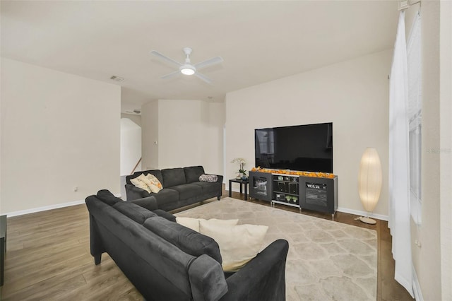 living room featuring wood-type flooring and ceiling fan