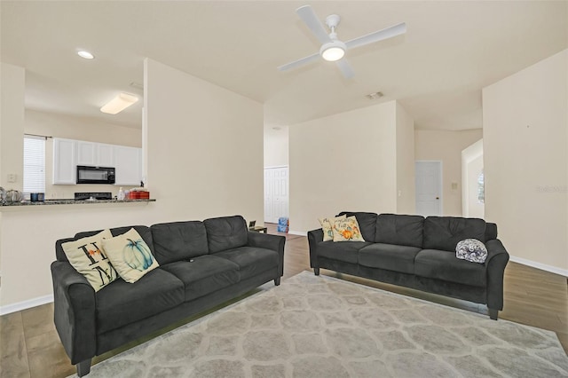 living room with light wood-type flooring, plenty of natural light, and ceiling fan