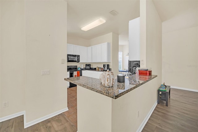 kitchen with white cabinetry, kitchen peninsula, light hardwood / wood-style floors, and stainless steel range with electric stovetop