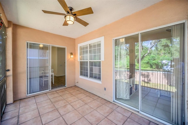 unfurnished sunroom with ceiling fan